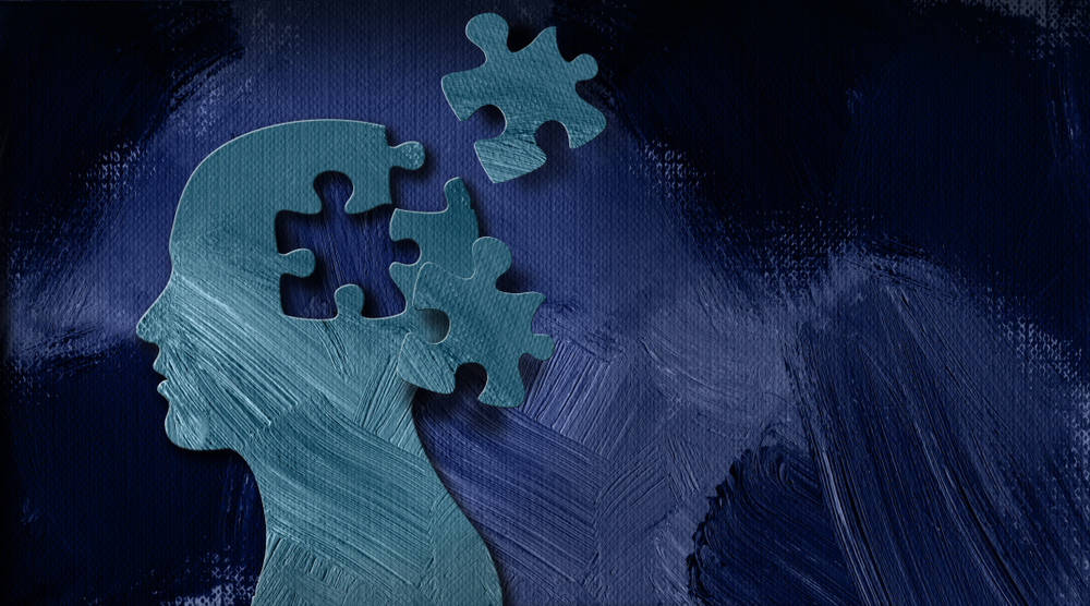 Abstract illustration of a human head made of puzzle pieces, with several pieces floating away, symbolizing cognitive diversity or neurological differences.
