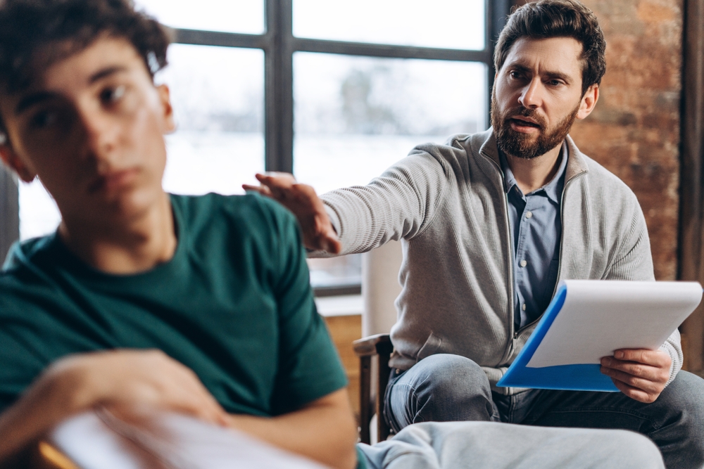 Therapist speaking with a teenage client during a counseling session