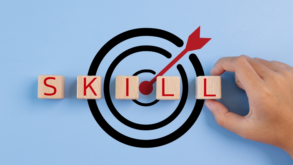 Wooden blocks spelling 'SKILL' with a target and arrow graphic, symbolizing skill-building 
