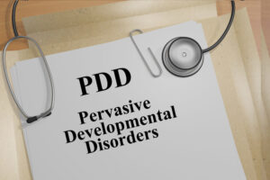 PDD: Pervasive Developmental Disorders with a stethoscope lying on a file folder.
